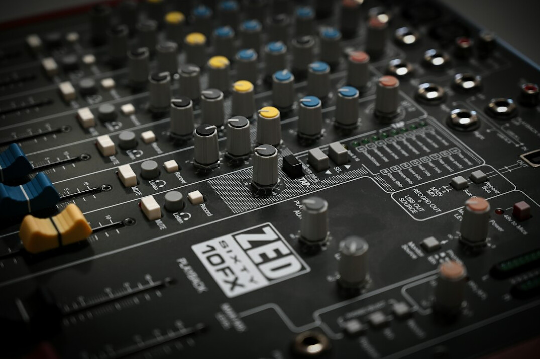 Audio mixing console with sliders and knobs